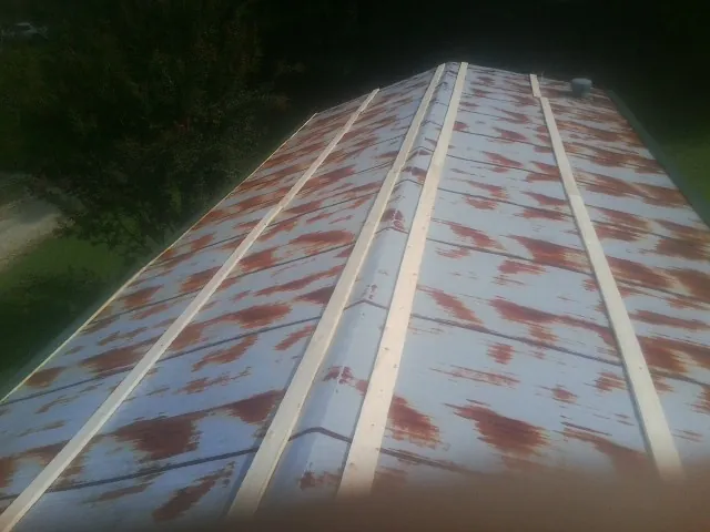Rusted metal roof panels with new wood purlins before replacement — Storm Damage Roof Repair in Nauvoo by Roofing Brothers