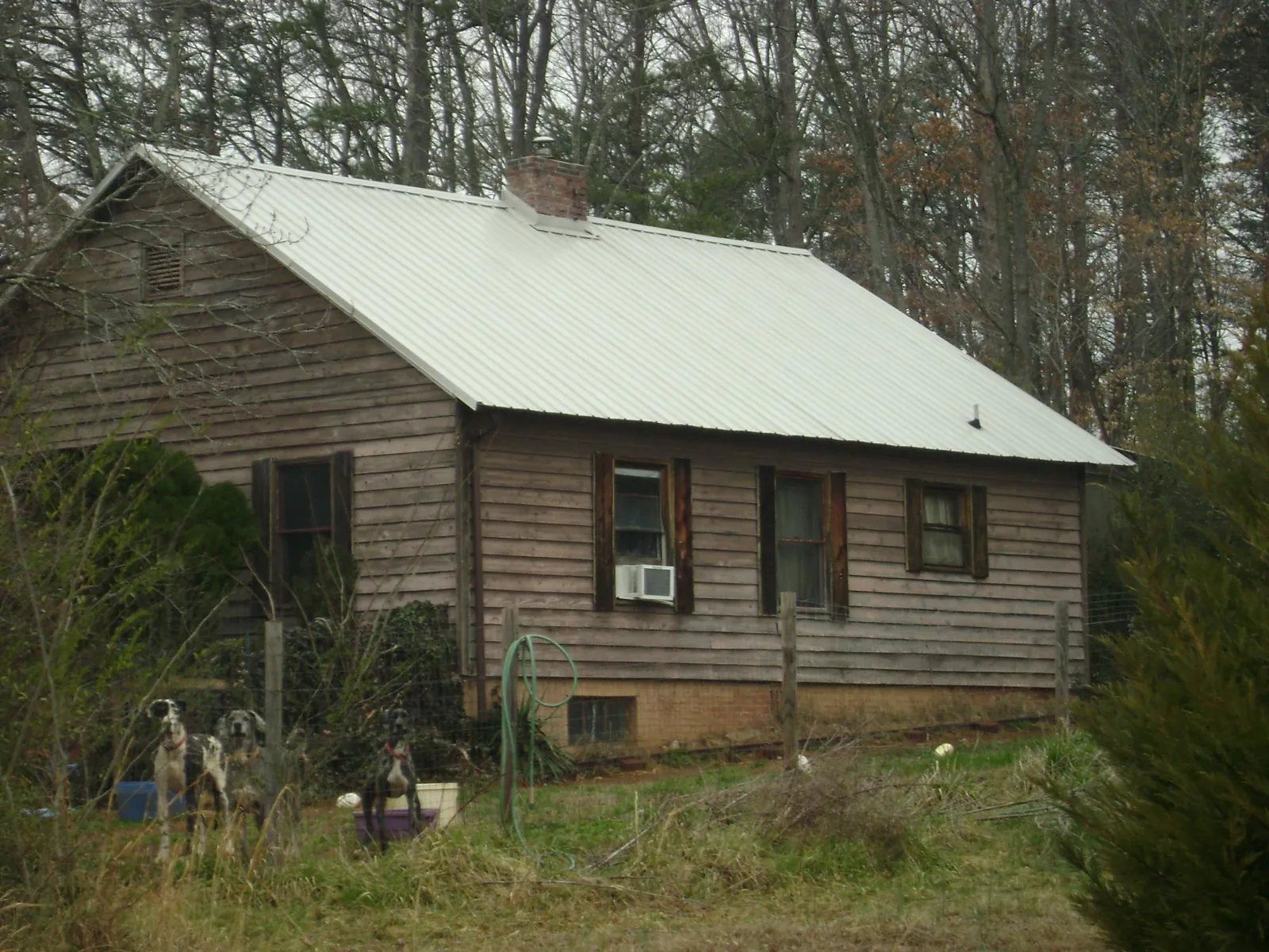 White metal roof on an old wood sided farmhouse, from a Metal Roof Installation job in Nauvoo